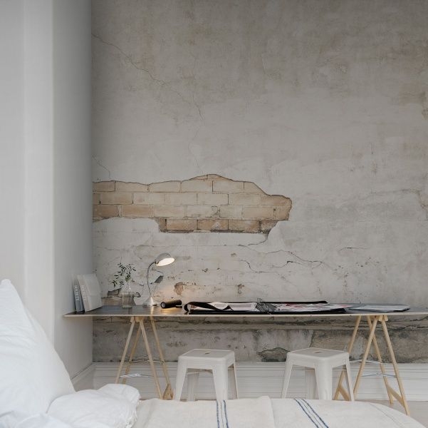 A simple and contemporary space done in neutrals with a catchy wall mural   a textural wall with a brick touch