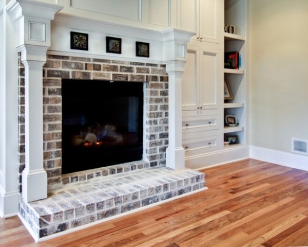 A whitewashed fireplace of dark brick looks not that bold and statement like but brings coziness and a stylish touch to the space
