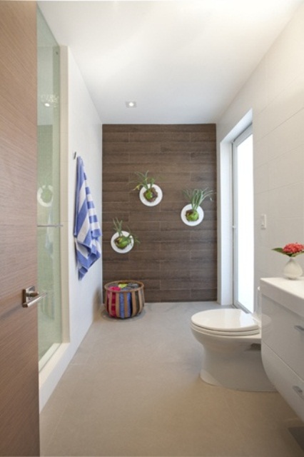 a contemporary bathroom with wall planters with greenery that enliven this space at once and make it fresher