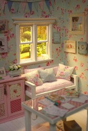 a pastel shabby chic kid’s room with floral walls, pastel furniture, floral and plaid bedding, a colorful banner over the space