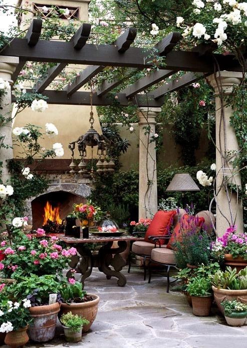 a bright and elegant patio with colorful blooms, dark stained furniture, elegant lamps and a chandelier