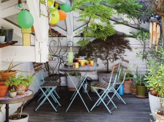 a bright boho patio with colorful balloons, potted greenery and a colorful chairs for dining