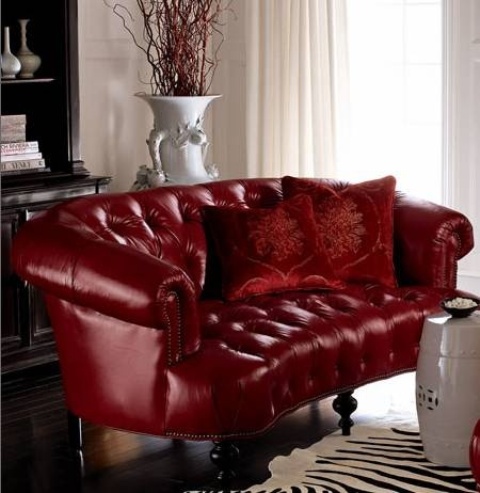A burgundy tufted sofa with a refined design is a stylish fall like statement for a living room