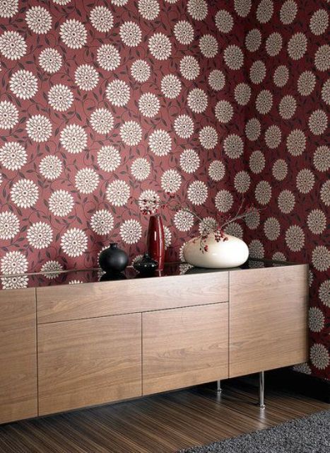 A wall done with retro inspired burgundy and gold printed wallpaper is a cool statement idea