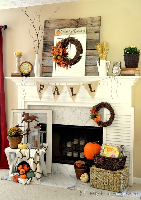 creative fall mantel decor with wheat, fall bloom arrangements, a burlap banner, faux pumpkins, a vine wreath and branches