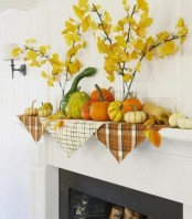 cozy rustic mantel styling with fall leaf branches in vases and real gourds and pumpkins on plaid napkins