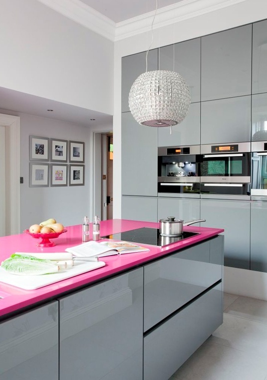 a minimalist glam kitchen done with shiny grey glossy cabinets, a hot pink kitchen island countertop and a shiny embellished pendant lamp