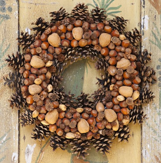 a fall wreath covered with pinecones, nuts of various kinds, acorns, various natural touches is a lovely idea that feels natural and rustic