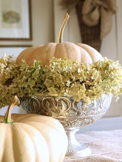 A vintage bowl with dried hydrangeas and a single white pumpkin is a stylish vintage inspired centerpiece or decoration