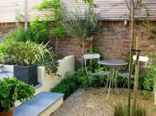 a cozy small garden space with built-in and metal furniture and some greenery around
