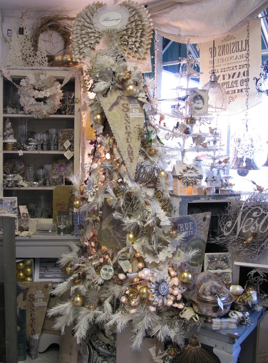 a whimsy white Christmas tree with lights, Christmas ornaments, white evergreens and signs