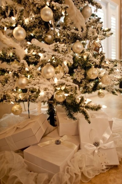 a flocked Christmas tree with silver and mother of pearl ornaments and lights looks really charming and chic