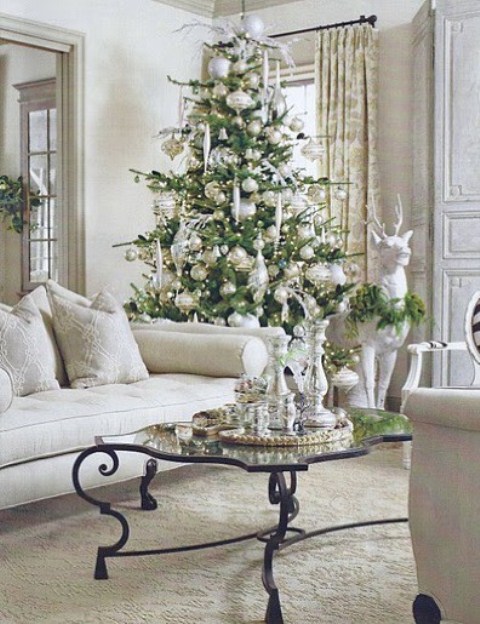a Christmas tree with sheer and silver Christmas ornaments, usual and oversized ones plus lights looks very charming
