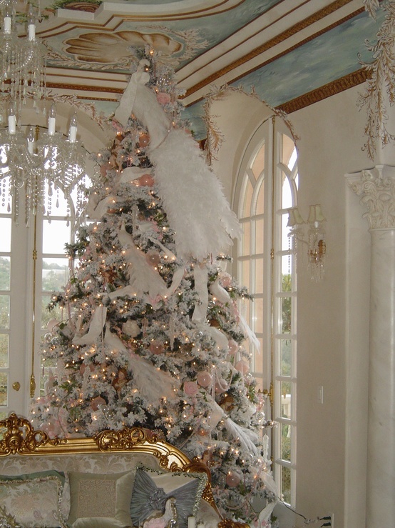 a flocked Christmas tree with pink ornaments, lights, white feathers and faux birds looks refined and very catchy