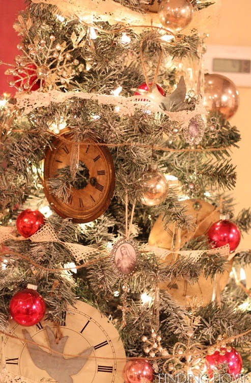 a Christmas tree with lights, vintage ornaments, clocks, snowflakes and pinecones looks very chic and cozy