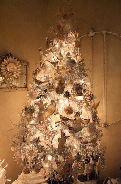 a white Christmas tree with lights and silver and white Christmas ornaments plus snowflakes