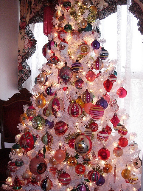 a vintage white Christmas tree with lots of colorful ornaments and lights is a cool idea with plenty of color