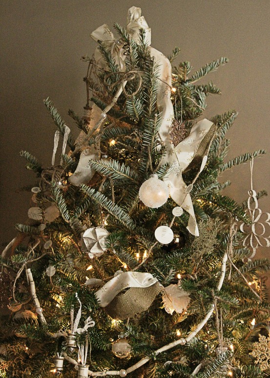 a vintage Christmas tree decorated with white ornaments, paper garlands, lights and ribbons