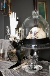 a cloche with a skull on black hay and a black ribbon is a stylish and elegant vintage Halloween decoration to go for