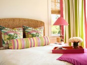 a neutral bedroom accented with bright colors – striped curtains and printed pillows, a fuchsia blanket and a tray, a pink table lamp looks amazing