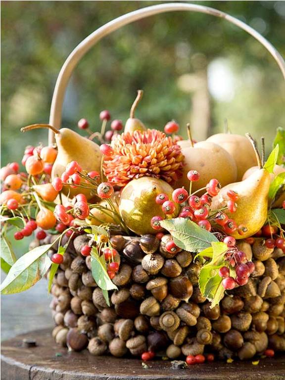A creative and all natural Thanksgiving centepiece of a basket covered with nuts, berries, pears and greenery is a gorgeous idea to go for