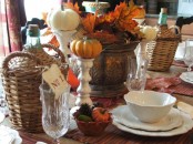 a pretty Thanksgiving centerpiece of a vintage vase with leaves, pinecones and pumpkins is a natural and fresh solution for the fall
