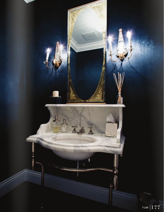 navy walls, a marble vanity and sink plus a mirror in a refined frame for a moody and elegant powder room