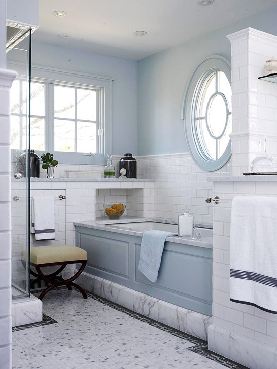 A vintage inspired light blue and white marble bathroom plus a round window with a frame