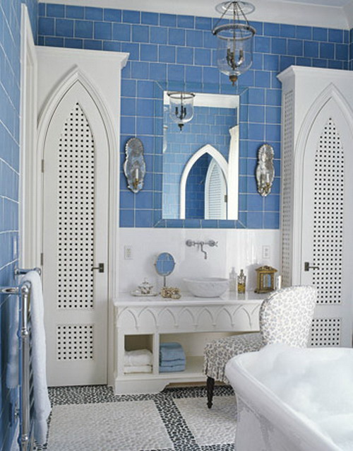 A vintage inspired bathroom with blue subway tiles and white touches and furniture