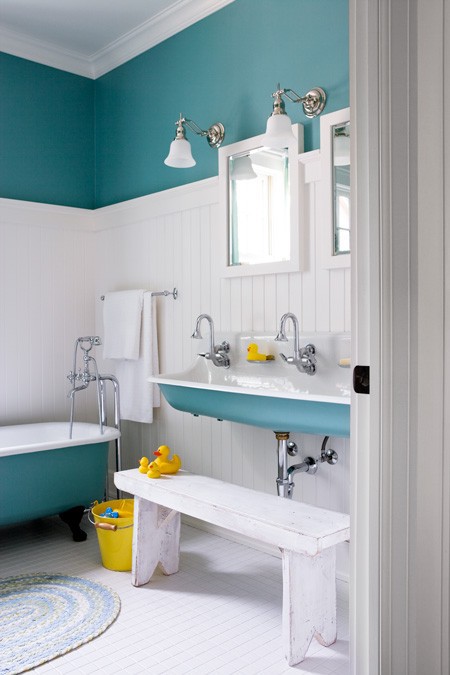 a turquoise wall, a clawfoot bathtub and a sink for a vintage and chic bathroom
