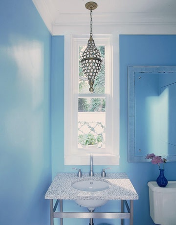 a bright blue bathroom refreshed with white touches and a crystal pendant lamp