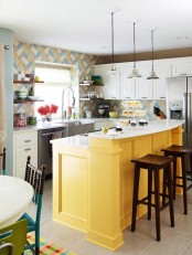 a bright kitchen with white cabinetry, a colorful tile backsplash and a bold yellow kitchen island is a fun and cool space with a beachy feel