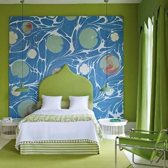 a bright green bedroom with a statement blue artwork, a green bed with greenery and white bedding is a unique space with plenty of color