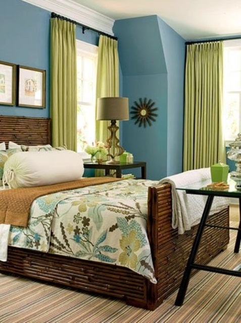 a dark stained bamboo wooden bed, bright green touches, a striped rug and blue walls