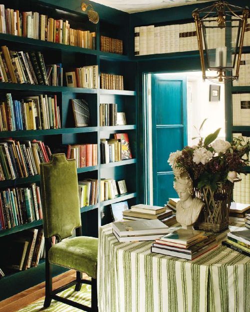 A refined home library with blue built in bookshelves taking all the walls is a very stylish and cool idea