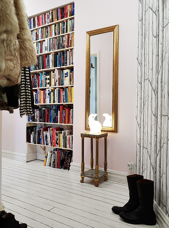 An entryway with lots of built in bookshelves that allow comfortable storage and doesn't steal space from other rooms