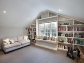 a neutral attic room with built-in bookshelves around the window – it’s a nice way to store things and save some space