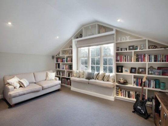 a neutral attic room with built-in bookshelves around the window - it's a nice way to store things and save some space