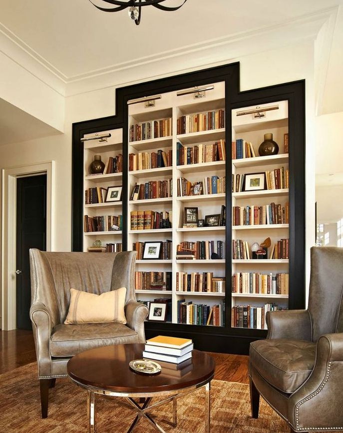 A refined living room with a whole cluster of built in bookshelves framed in black is a very elegant and stylish piece