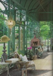 a vintage blue green sunroom with elegant and refined blue garden furniture, elegant candle holders and lanterns, a crystal chandelier is welcoming