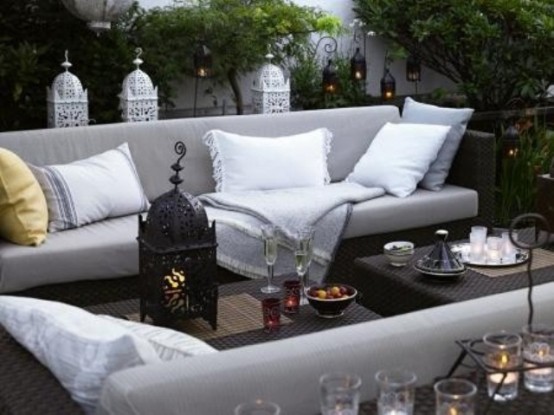 a neutral terrace decorated with Moroccan lanterns and comfy contemporary furniture