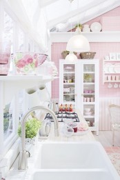 a romantic pink and white vintage kitchen with plaid wallpaper, striped paneling, white furniture and a glazed wall plus printed textiles
