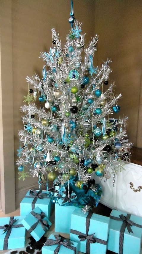 a silver Christmas tree with blue, green and silver ornaments and beaded garlands is a very bright and shiny idea