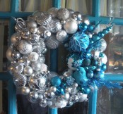 a pretty silver, white and blue Christmas wreath with feathers, beads and branches is a lovely decoration to rock
