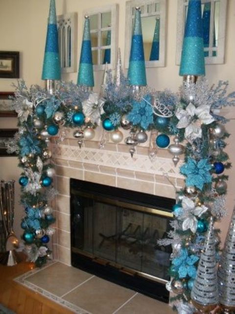 frozen blue and silver Christmas decor with a fir garland with blue, turquoise and navy ornaments and snowflakes and faux color block Christmas trees in silver, blue and navy