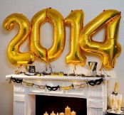 gold number balloons attached over the fireplace will be a nice and easy NYE decoration, you can make it last minute