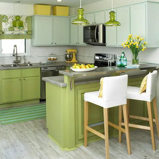 a bright traditional kitchen with green lower cabinets, light blue upper ones, yellow appliances, pilllows and and blooms and fruits