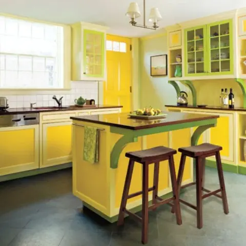 a stylish vintage kitchen with yellow and green cabinets, a neutral tile backsplash, a green wall and a bright yellow door