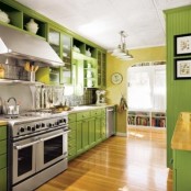 a stylish bright kitchen with yellow walls and bright green cabinets, touches of stainless steel and natural light