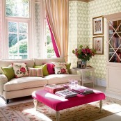 bold and floral print pillows and an ottoman, pink striped curtains and blooms for a summer living room